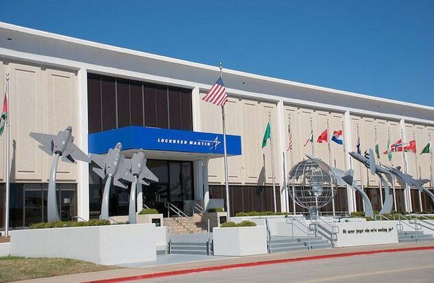 Lockheed Martin Aeronautics facility entrance in Fort Worth, with fighter-jet sculptures and international flags